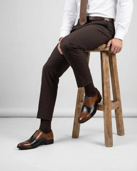 Man wearing brown and black two-tone leather brogue dress shoes