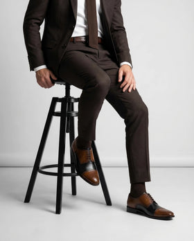 Man wearing brown two-tone leather dress shoes with a dark suit
